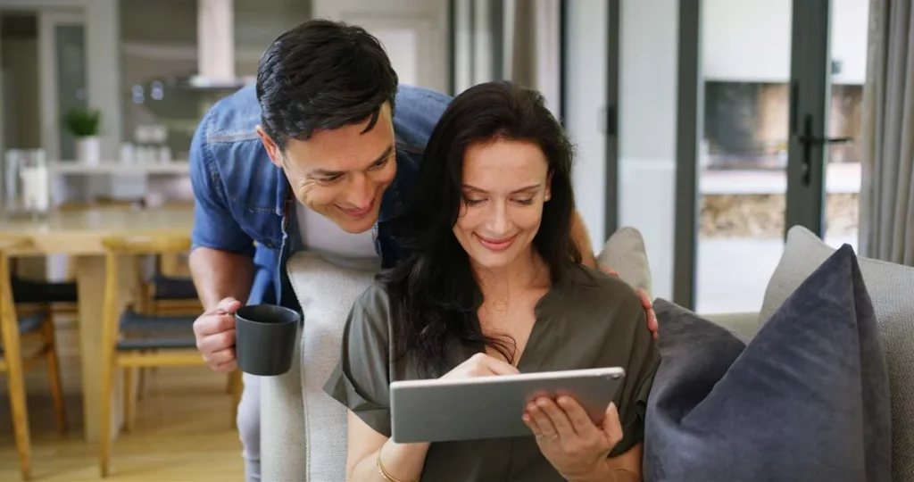 A couple selecting custom home organization service plans on a digital tablet