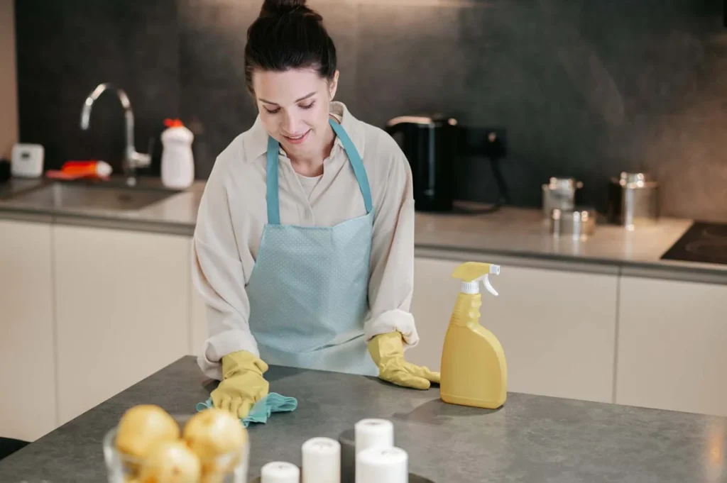 A professional cleaner wiping down a kitchen counter during a residential house cleaning