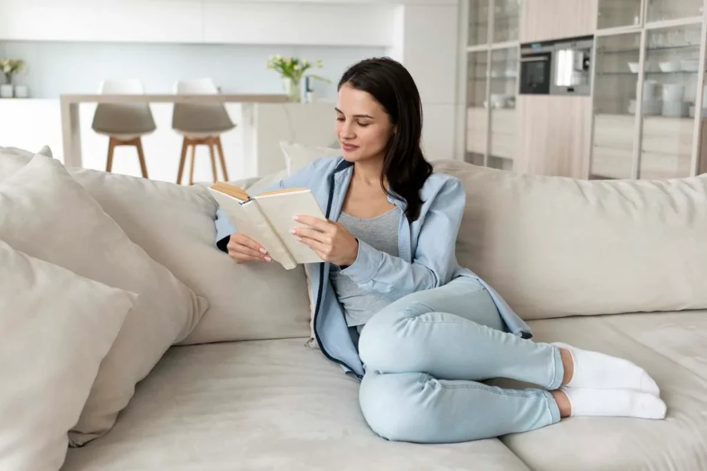 A relaxed homeowner reading a book in their professionally cleaned living room