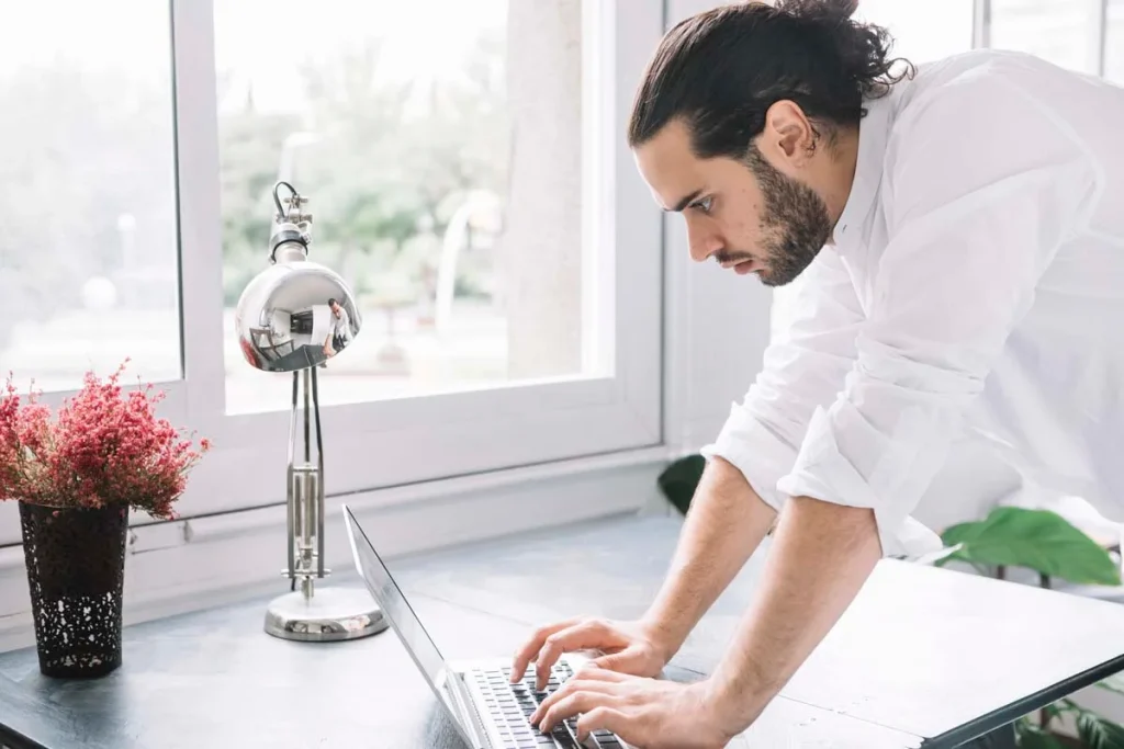 A business owner typing on a laptop to request a commercial cleaning quote online